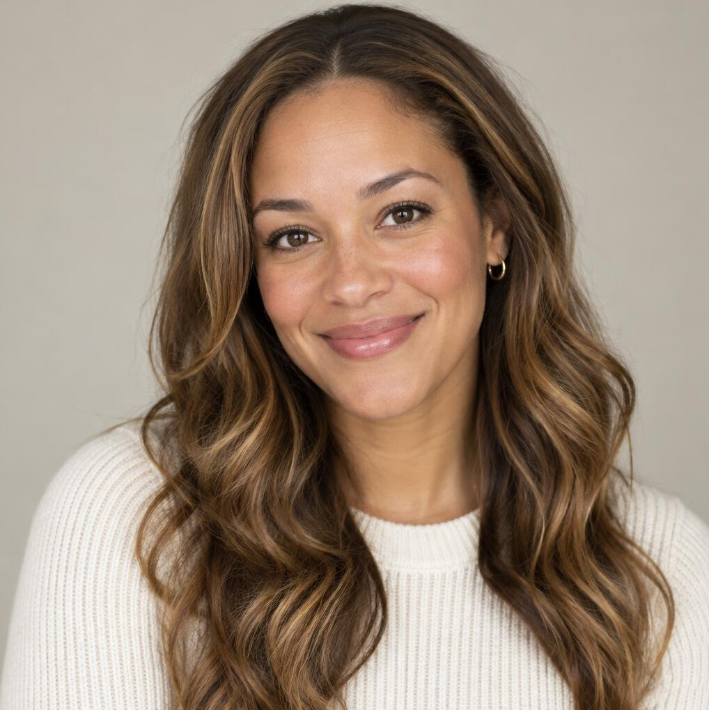Portrait of a woman in her thirties with long wavy hair and a warm smile