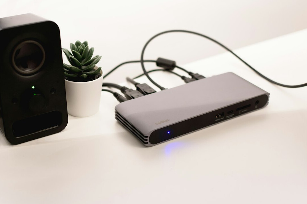 Laptop and streaming encoder with cables on a desk for a live stream setup